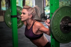A woman performing a back squat exercise in a gym