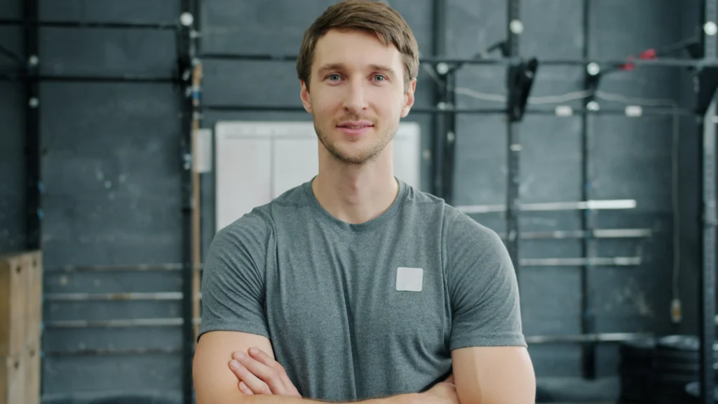 Man standing with arms crossed at the gym