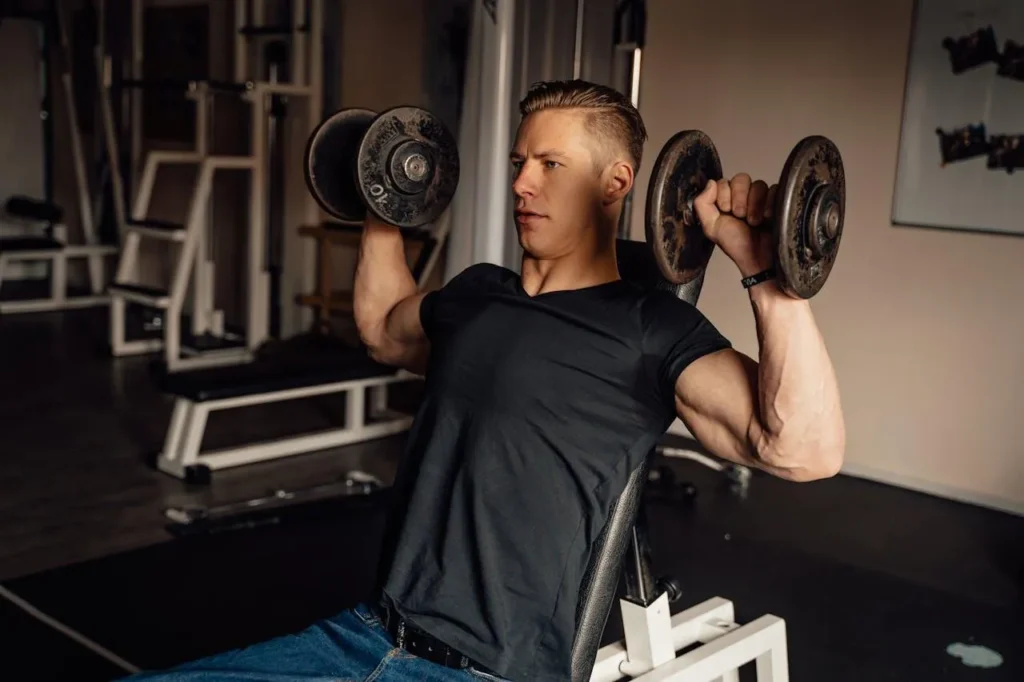 Man training both arms with dumbbells at the gym