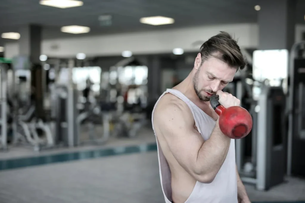Man doing an arm workout with a kettlebell at the gym