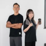 Personal trainer and client standing back-to-back with focused expressions