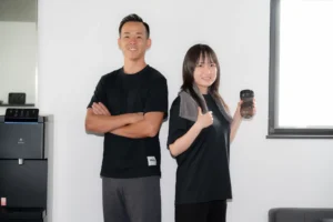 Personal trainer and client standing back-to-back with focused expressions