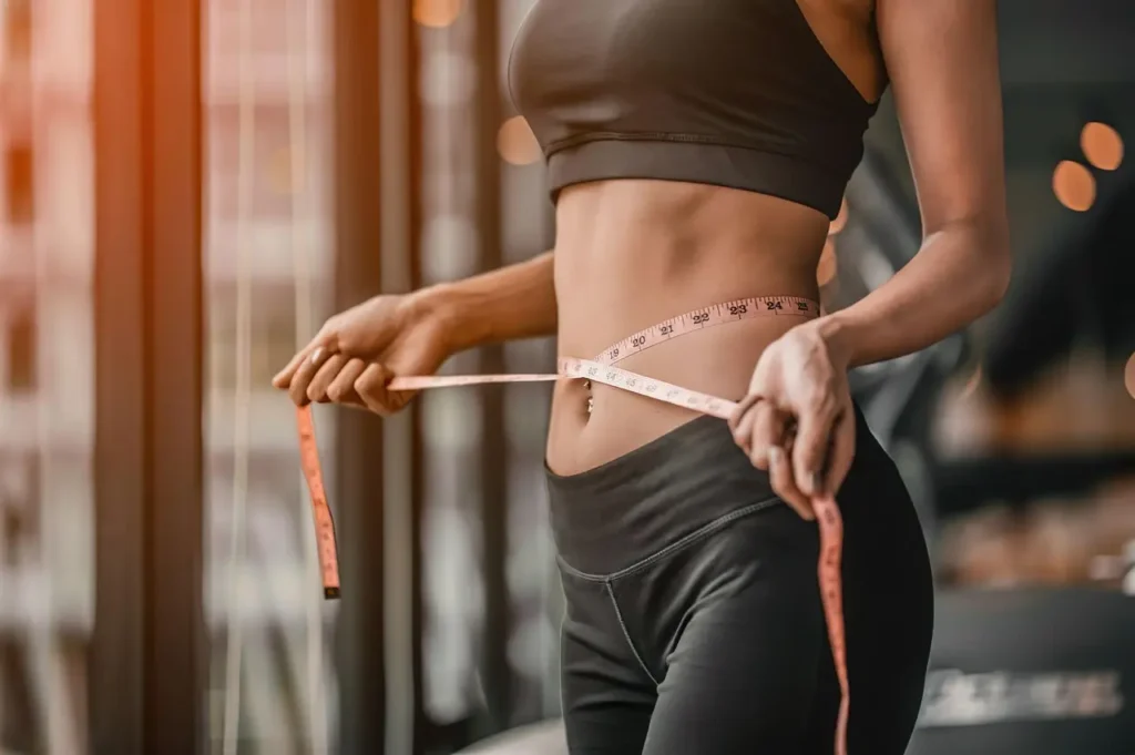 Photo of a woman measuring her waist size