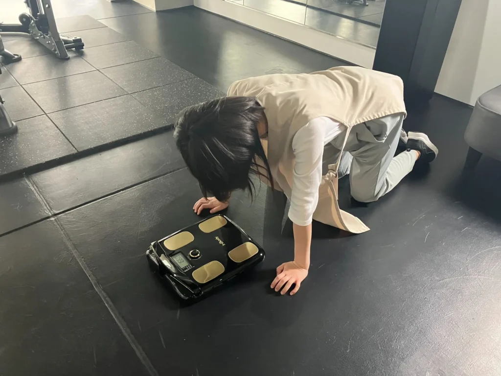 体重計の前で落ち込んでいるデザイナーNさんの写真