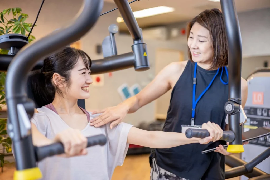A female trainer instructing machine training in the gym