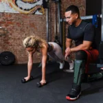 パーソナルトレーナーの指導のもとでプランクをしている女性の写真
