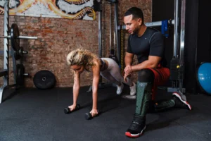 パーソナルトレーナーの指導のもとでプランクをしている女性の写真