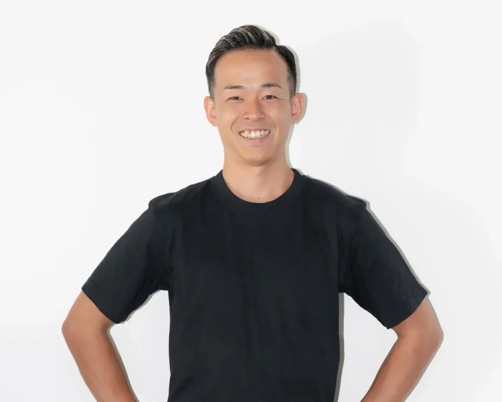 腰に手を当てて笑顔のパーソナルトレーナー