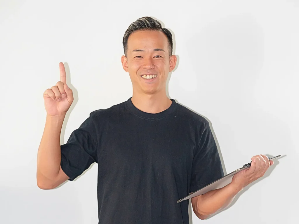 笑顔で人差し指を上げ、ポイントを示すパーソナルトレーナー