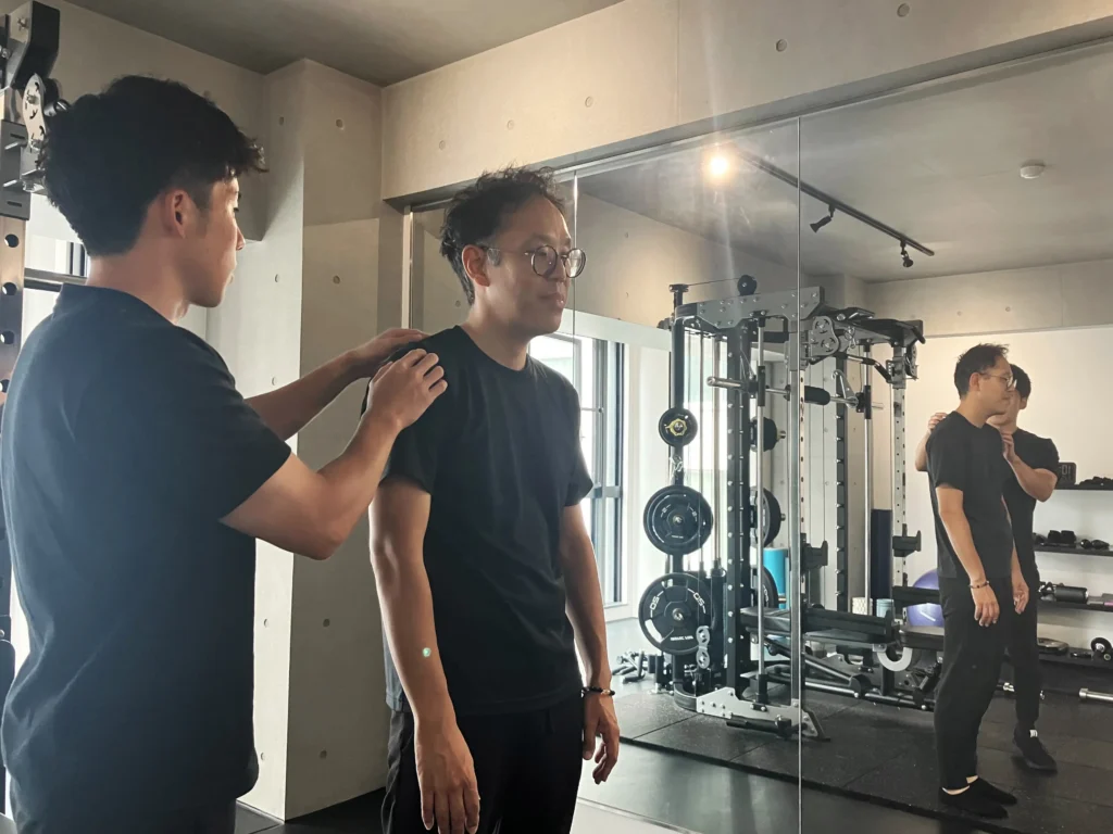 腰痛・姿勢改善を目的とした40代男性のお客様が姿勢改善についてアドバイスを受けている様子