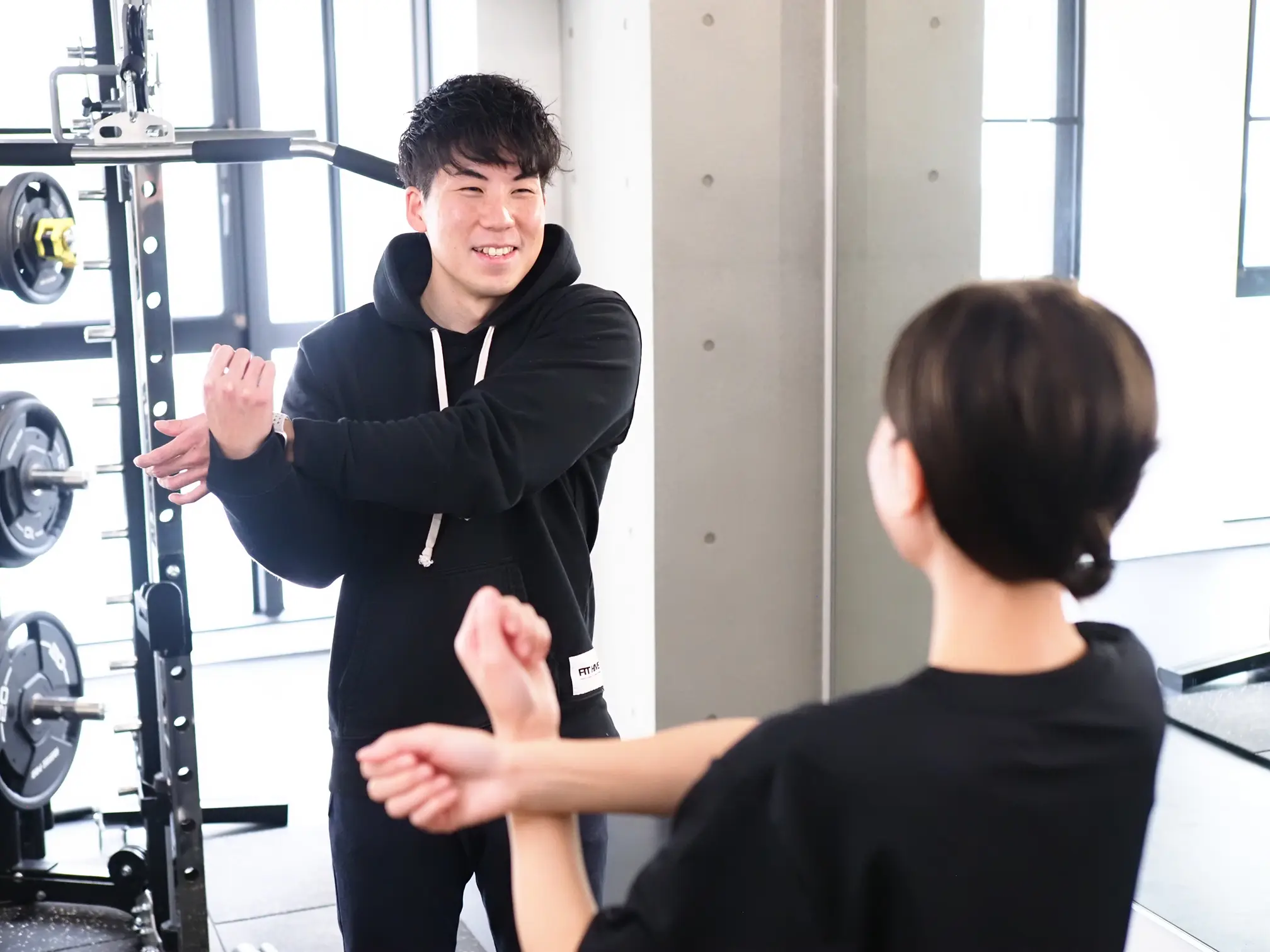 女性がパーソナルトレーニングを受ける前にウォームアップをしている写真